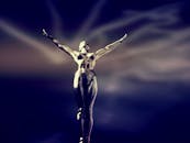 在戏剧性的灯光下，抽象金属雕塑伸出了手臂