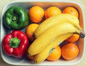 碗里装满了香蕉和辣椒等新鲜水果和蔬菜