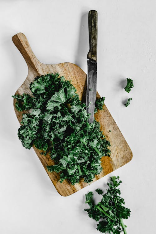 Free Close-Up Shot of Chopped Kale on a Wooden Chopping Board Stock Photo