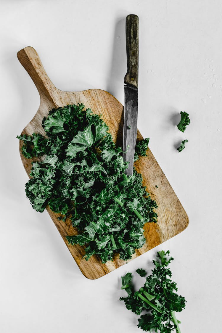 Close-Up Shot Of Chopped Kale On A Wooden Chopping Board