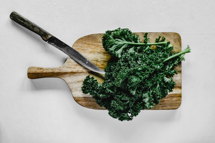 Close-Up Shot Of Kale On A Wooden Chopping Board