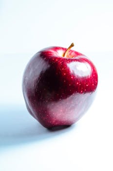 High-quality image of a fresh, shiny red apple with a white background.