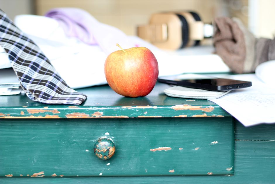 A stylish desk with a red apple, smartphone, tie, and documents for a modern office vibe. A stylish desk with a red apple, smartphone, tie, and documents for a modern office vibe.