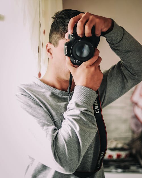 A Man in a Gray Sweater Taking a Photo