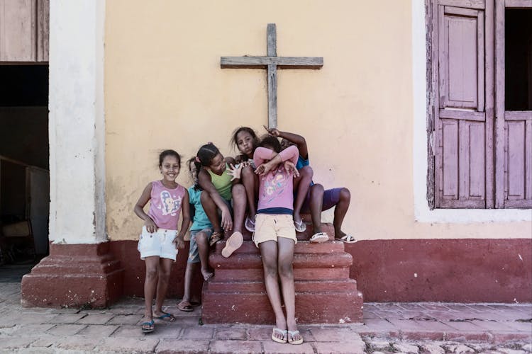 Cheerful Hispanic Children Having Fun On Street Near Church