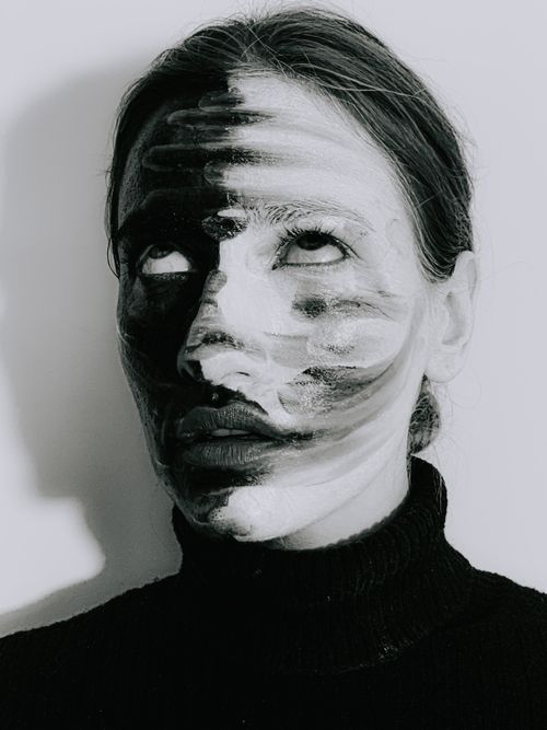 Free Black and white of young bored female with painted face rolling eyes against light background Stock Photo