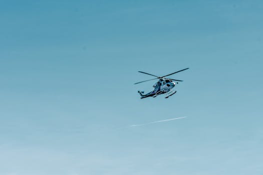 From below of modern helicopter flying in cloudless blue sky on sunny day