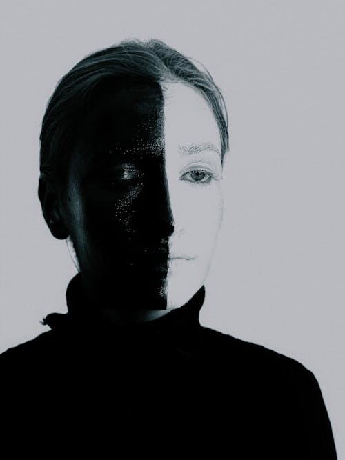 Free Thoughtful young woman with dark and light painted face Stock Photo