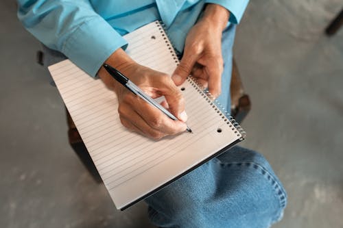 Personne En Jeans Denim Bleu Tenant Un Stylo Noir écrit Sur Un Ordinateur Portable Blanc