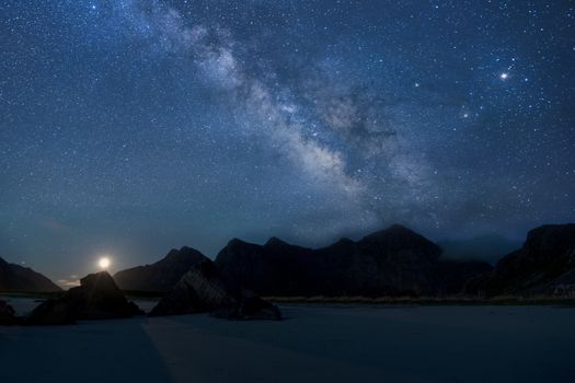 夜间，从山脉轮廓和湖泊上方俯瞰，银河系的景色令人惊叹