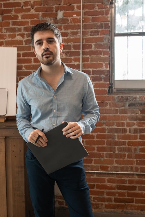 Homem De Camisa Social Azul Segurando Um Computador Tablet Preto