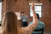 A Bearded Man Pointing the Pen at the Person Raising Hand