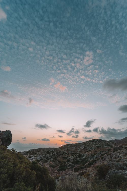Free Breathtaking sunset view over the mountainous terrain of Crete, Greece with dramatic cloud formations. Stock Photo