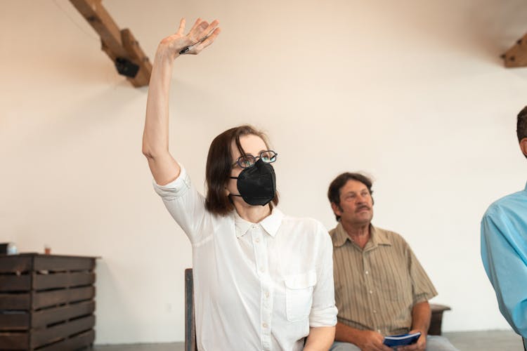 Woman Wearing Facemask Raising Hand