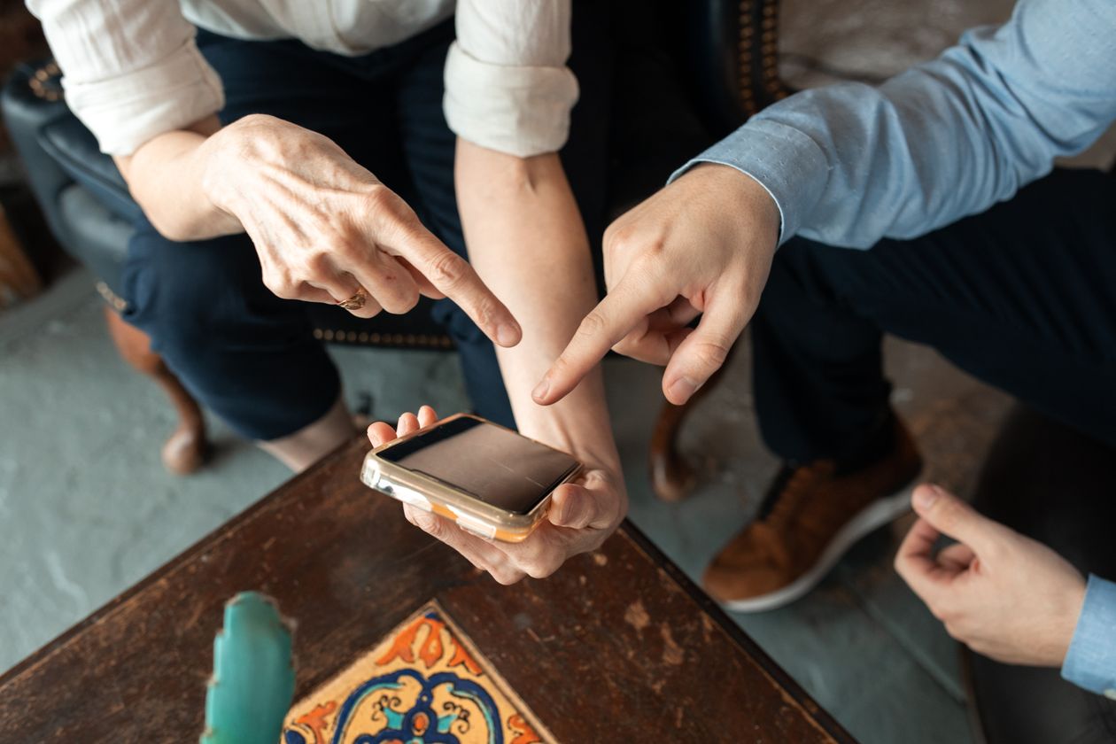 Pessoas analisando uma negociação pelo celular