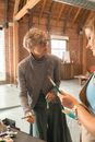 一位高级女艺术家在乡村工作室里用颜料和画笔教一名年轻人