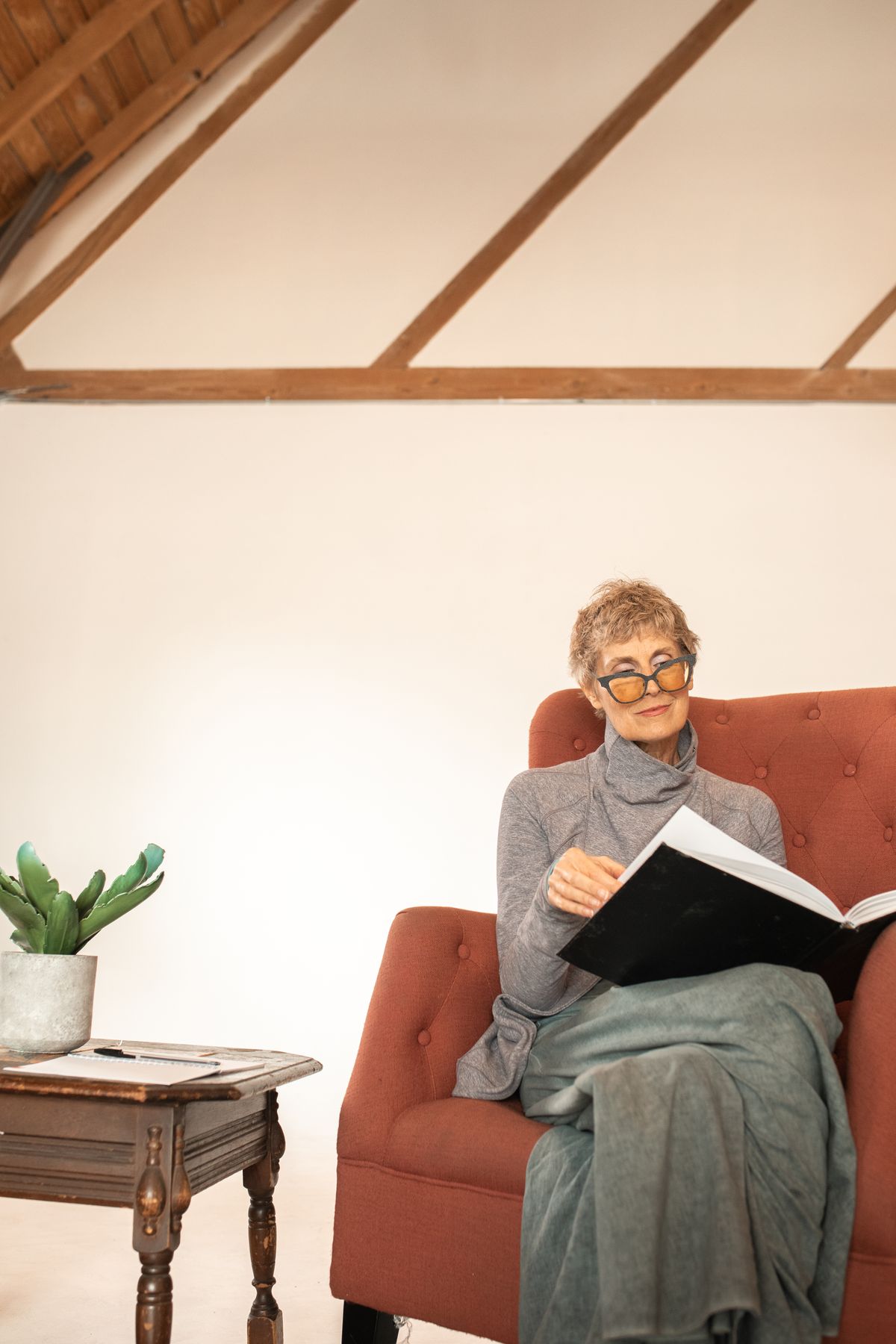 Senior woman reading a book in a cozy armchair