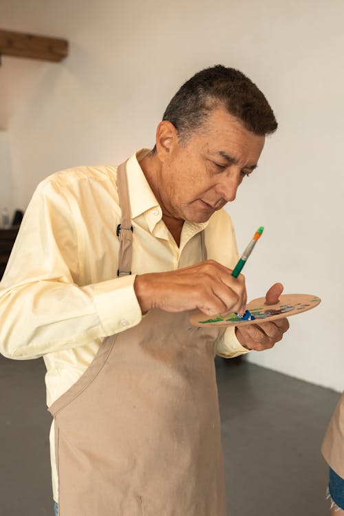 A Man Squeezing Paint in a Color Palette