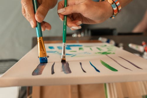Gratis Persona Sosteniendo Un Pincel De Pintura Verde Foto de stock