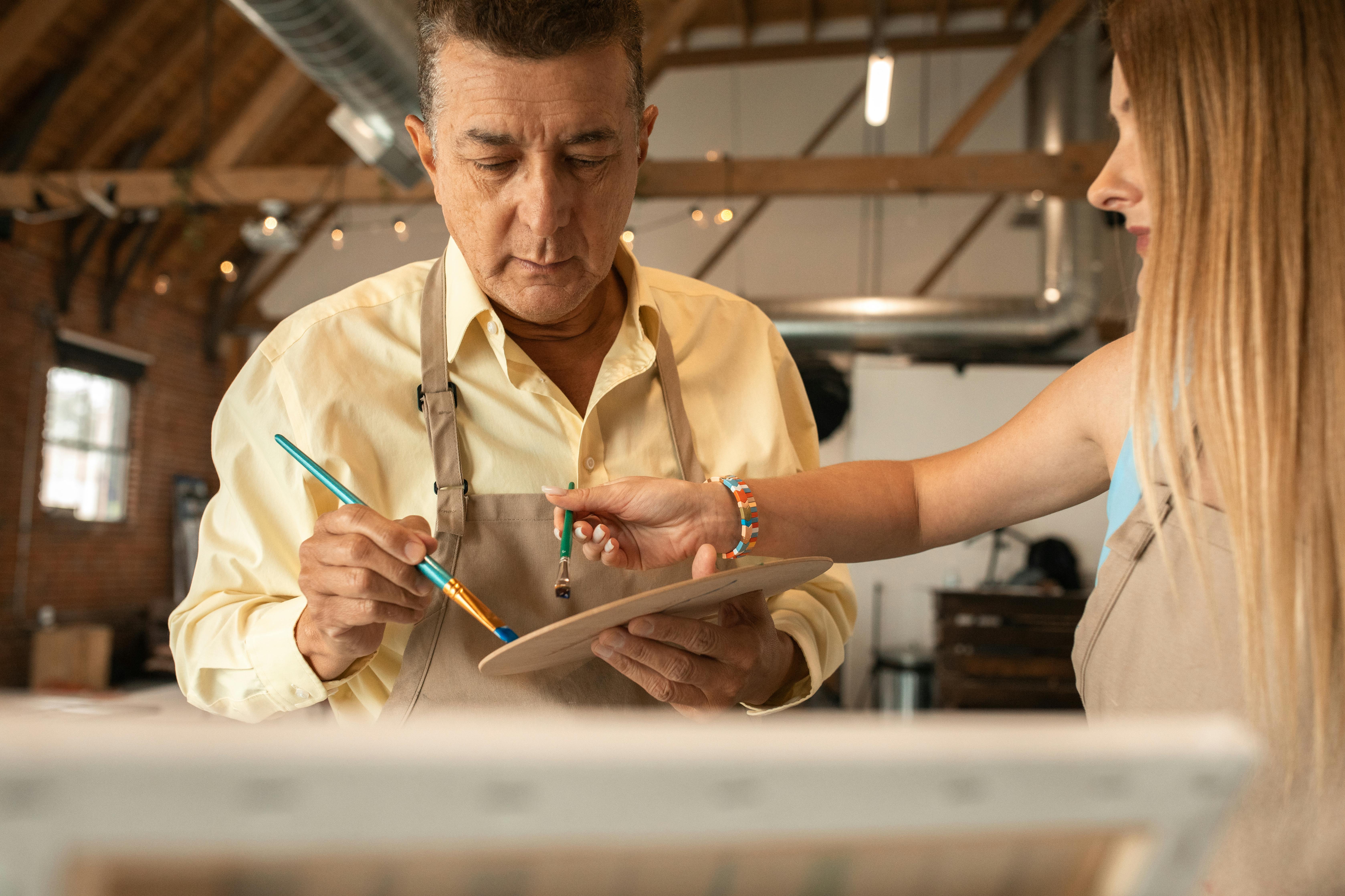 Two artists collaborating in a modern studio, focused on creating vibrant artwork.