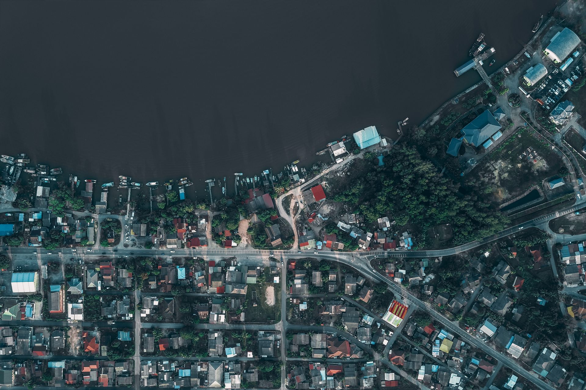 Coastal city with residential houses and port with moored boats