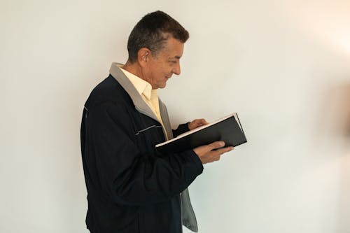 남자 흰색 태블릿 컴퓨터를 들고 검은 정장 재킷