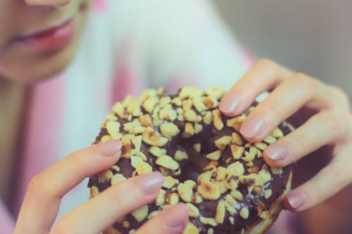 초콜릿 도넛을 들고있는 사람