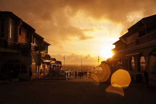 Silhouette of buildings and people on a street facing the sea at sunset in Soorts-Hossegor, France.