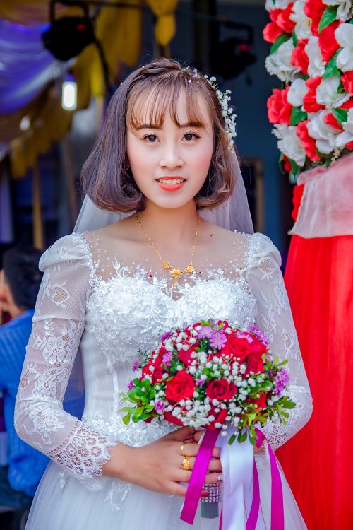 Free Smiling bride in elegant white dress holding a vibrant bouquet, perfect for wedding themes. Stock Photo