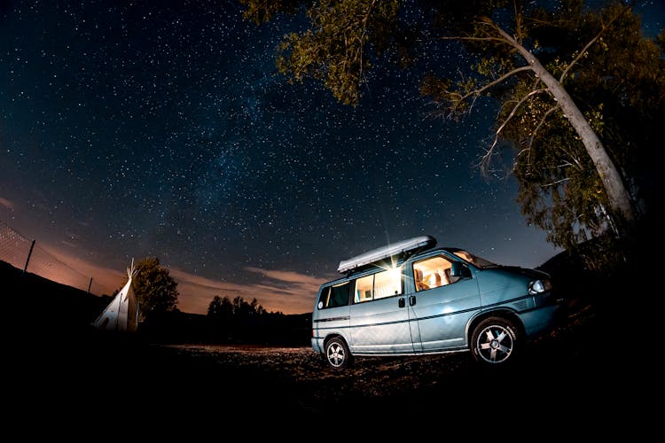 A Van Parked In A Camp Site At Night