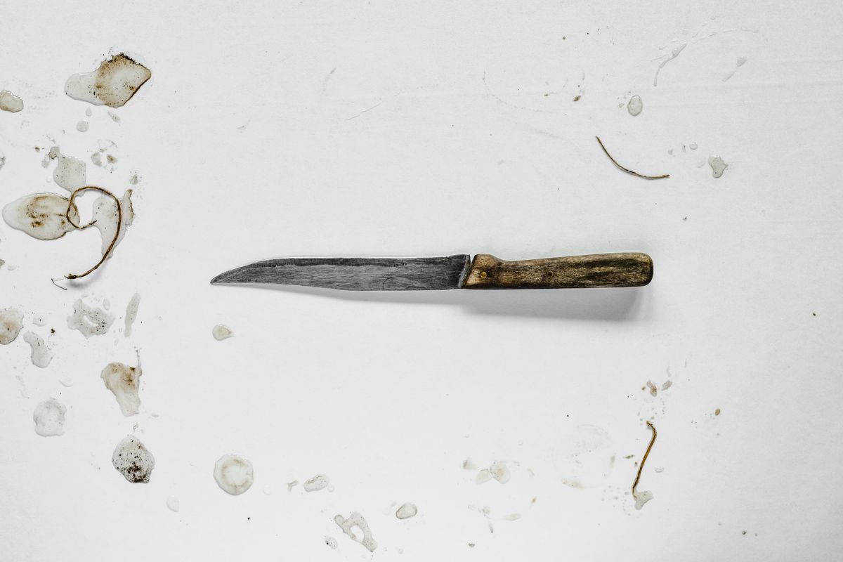 How to dispose of kitchen knives safely: assessing an old blade A worn kitchen knife with a wooden handle showing stains and wear, ready for disposal decisions