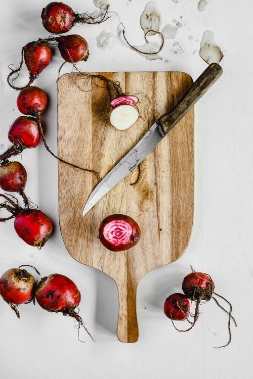 Free Top view of chioggia beets being sliced on a wooden board with a knife, showcasing fresh nutrition. Stock Photo
