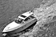 一张高对比度的黑白照片捕捉到一艘优雅的游艇在河上航行