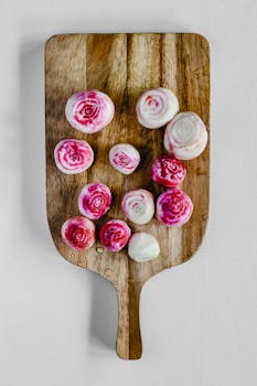 Fresh sliced Chioggia beets with vibrant patterns on a wooden board, isolated on white.