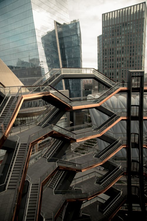Futuristic Hudson yards redevelopment project with staircases located on street near modern skyscrapers in downtown of famous megapolis in Manhattan