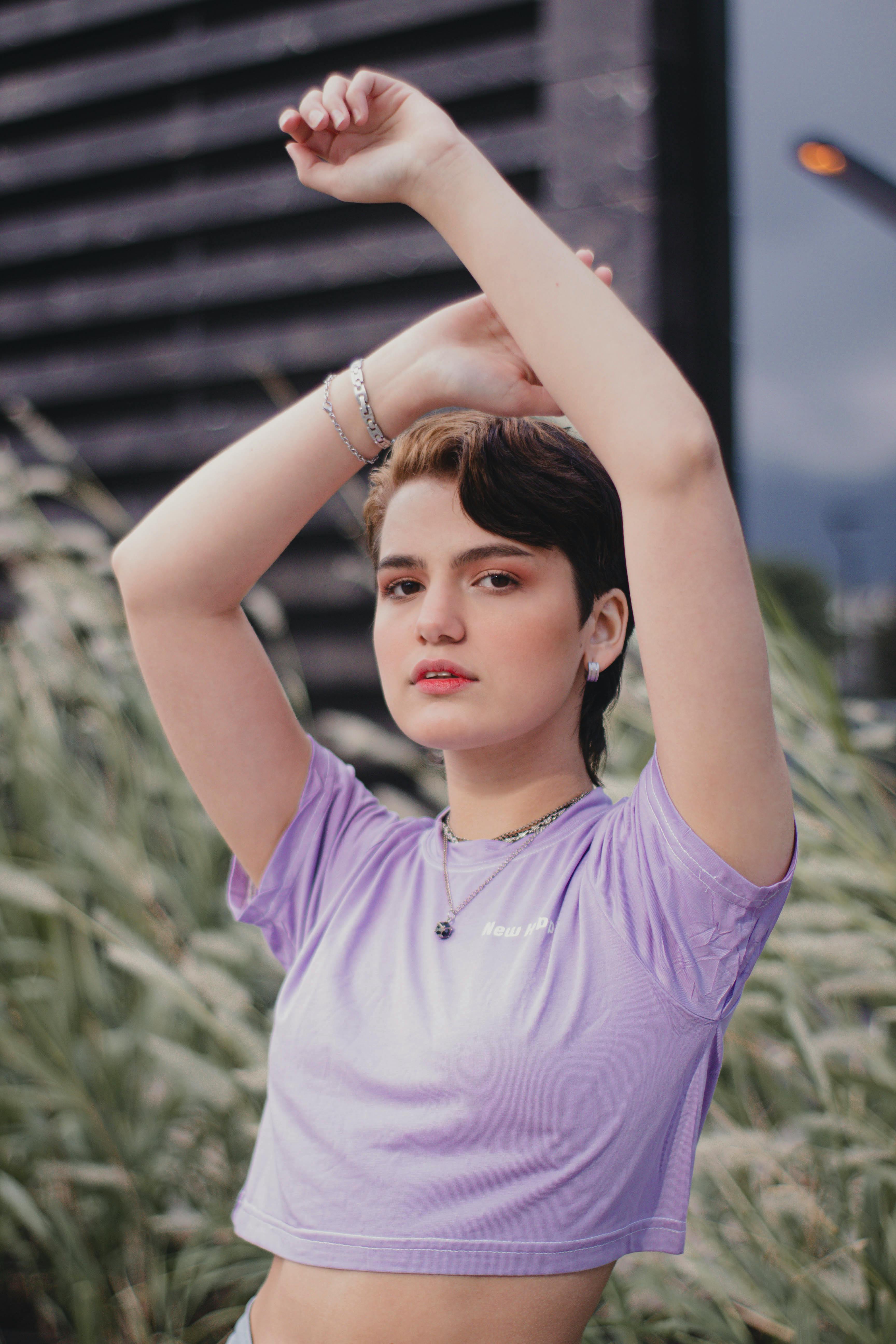 woman in purple crop top t shirt raising her hands