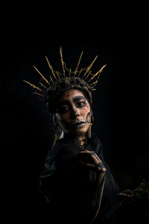 Free Captivating artistic makeup of a woman embracing Dia de los Muertos with a striking golden crown. Stock Photo