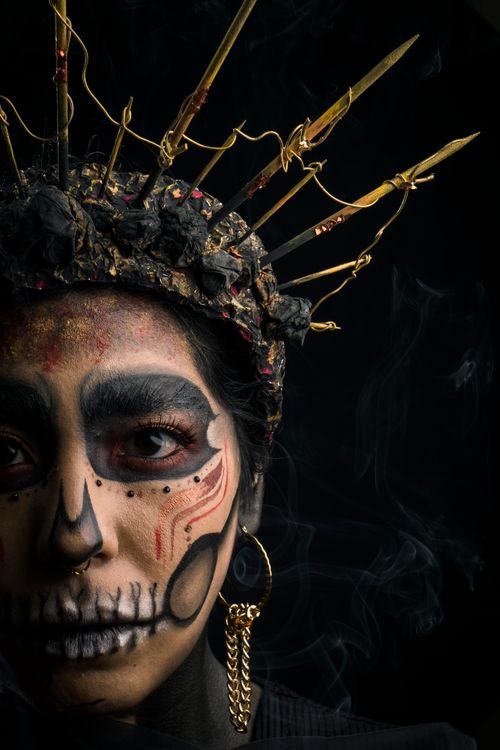 Free A striking portrait of a woman in Dia de los Muertos makeup with a creative crown, capturing cultural essence. Stock Photo