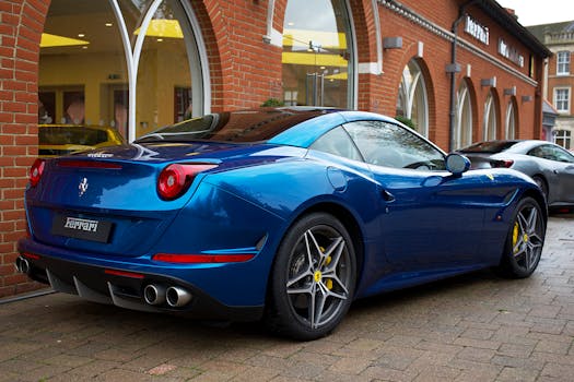 Sleek blue Ferrari sports car parked outside a dealership in the UK, showcasing luxury design.