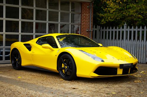 Free Yellow Ferrari sports car parked outside a garage in the UK. Stock Photo