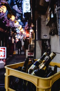 灯火通明的城市小巷里，板条箱中的啤酒瓶特写