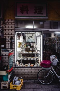 这家日本店面很舒适，外面停着自行车，橱窗里陈列着各种物品