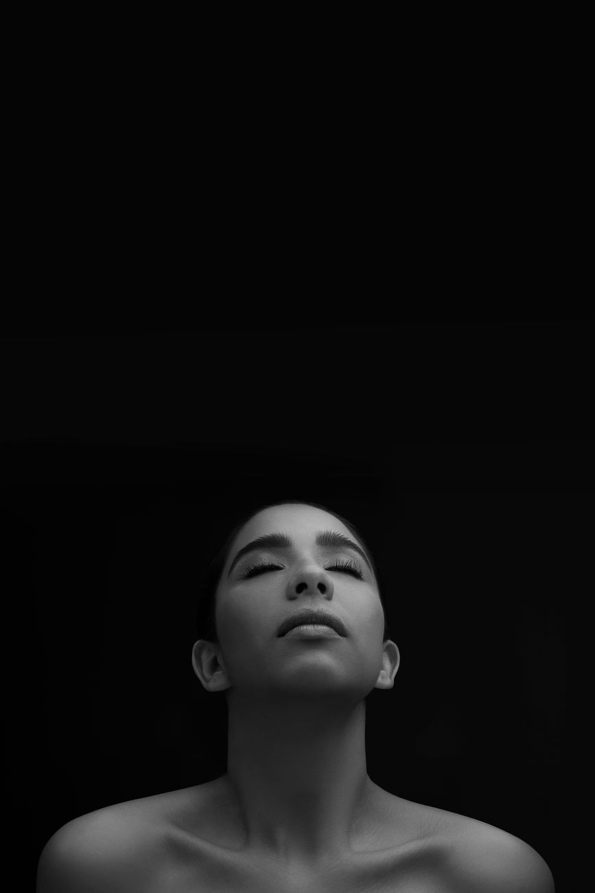 Elegant grayscale studio portrait of a woman with eyes closed, exuding calmness and serenity.