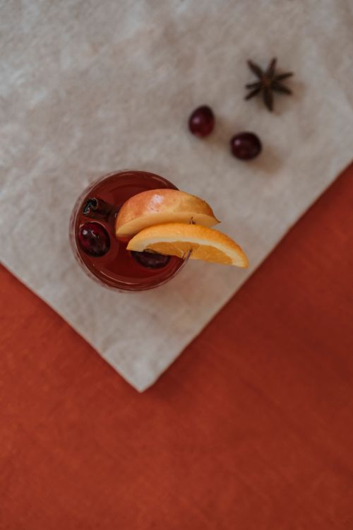 Free A refreshing drink of cranberry juice with orange slices and star anise on a linen napkin. Stock Photo