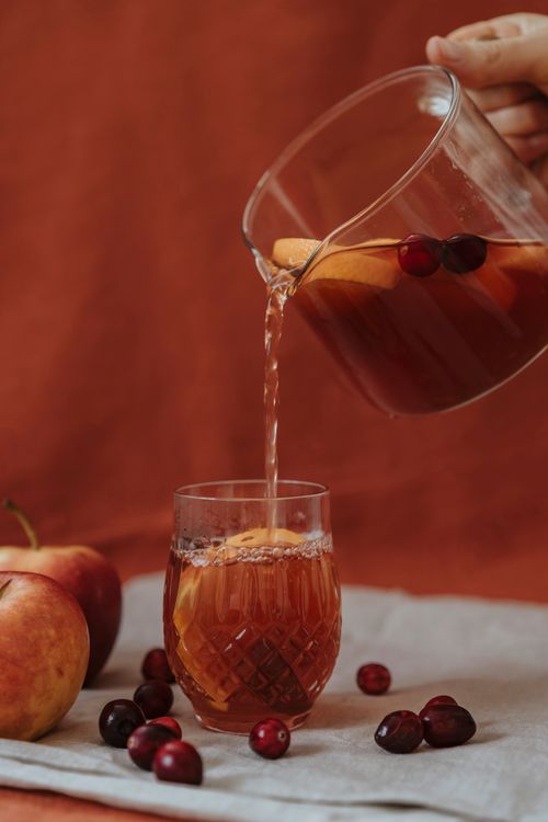 Free Enjoy a soothing autumn beverage with fresh apples and cranberries in a glass cup. Stock Photo