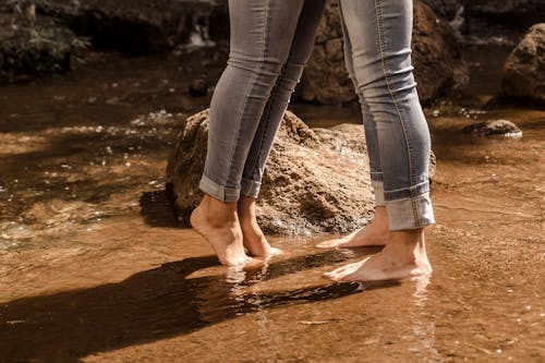 Two People Standing Barefoot in Water