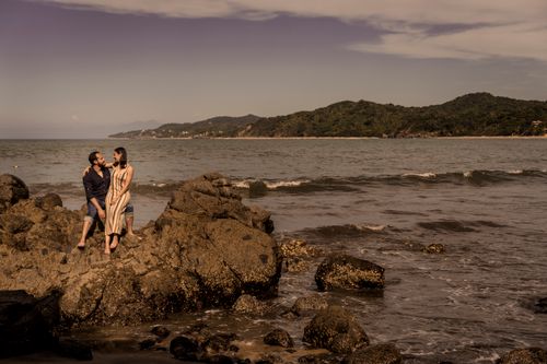 Free Romantic couple embracing on the rocky coastline of Sayulita, Mexico, with scenic ocean views. Stock Photo