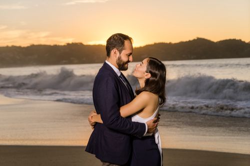 Free A loving couple embracing on a beach at sunset, capturing romance and happiness. Stock Photo