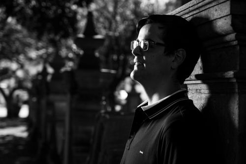 Free Black and white portrait of a man leaning against a wall outdoors. Stock Photo