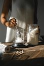 Crop black woman weighing wax in glass jar